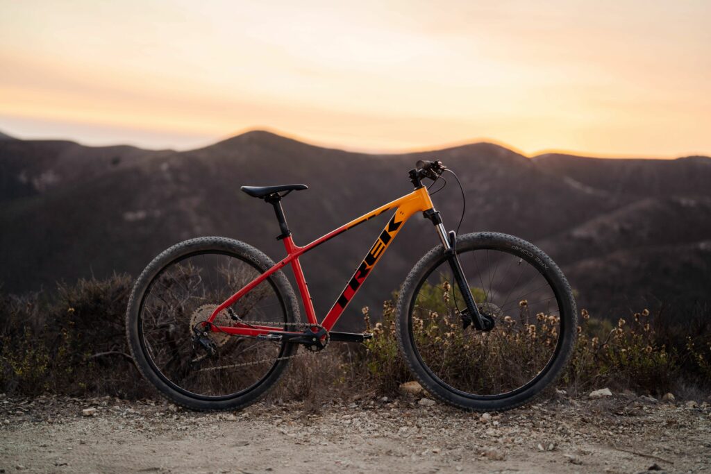 A trek marlin hardtail mountain bike side on against a sunset mountain backdrop. One of the types of mountain bikes that are more affordable.
