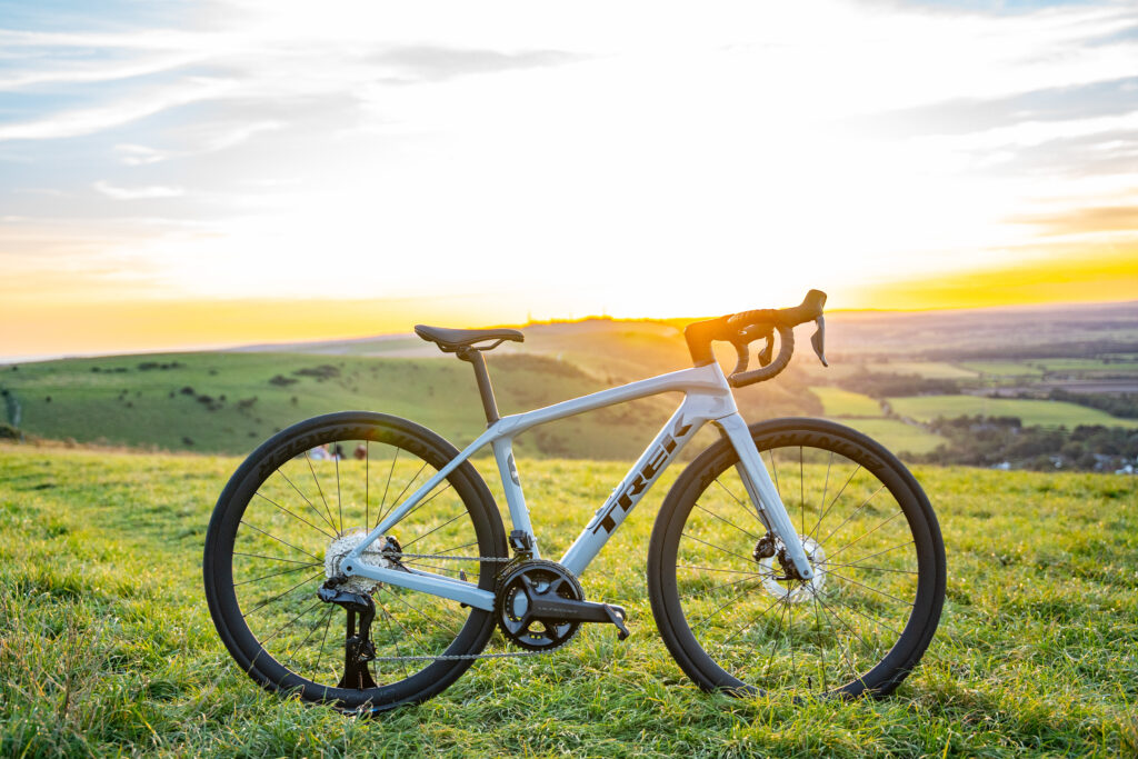 A grey Trek Domane SL 7 sits on top of Devils Dyke at Sunset