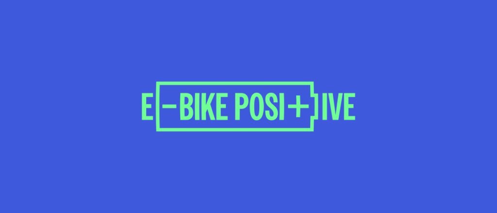 The e-bike positive campaign logo in bright green in centre of image on a bright blue background